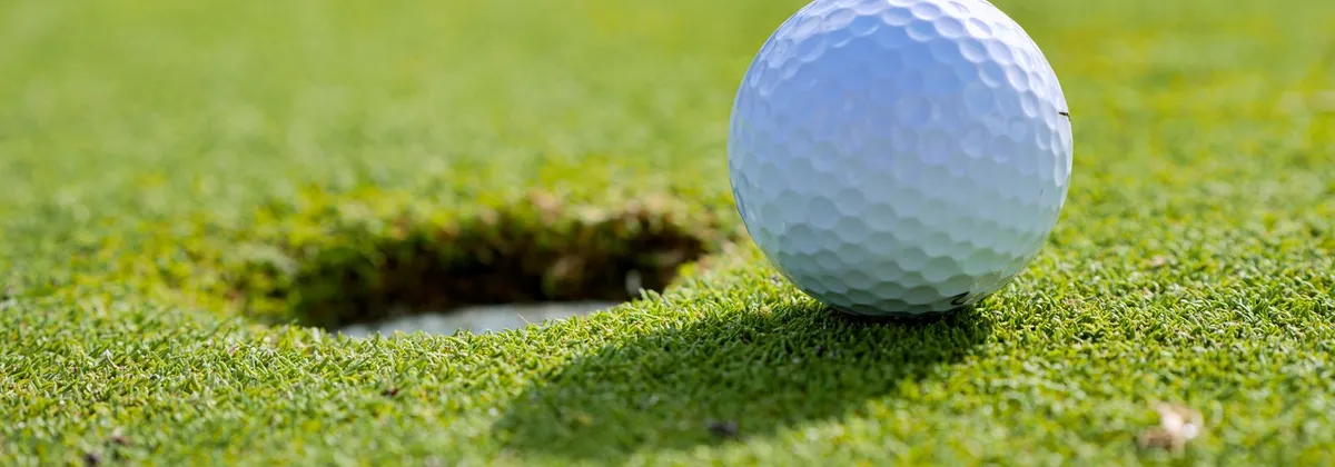 Balle de golf près du trou sur un green